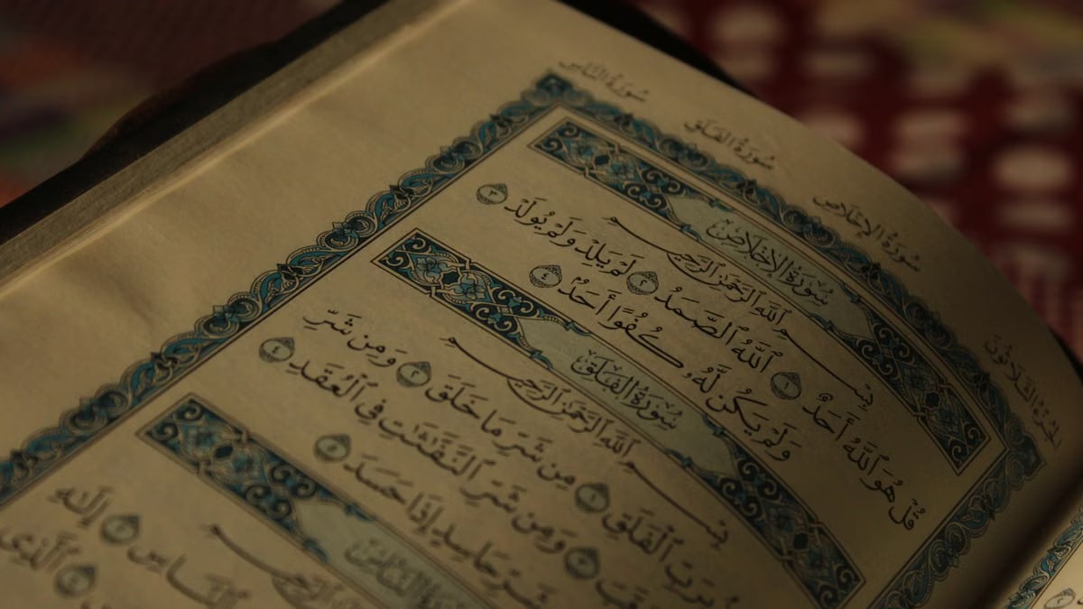 An open Quran showing intricate Arabic calligraphy and decorative designs.